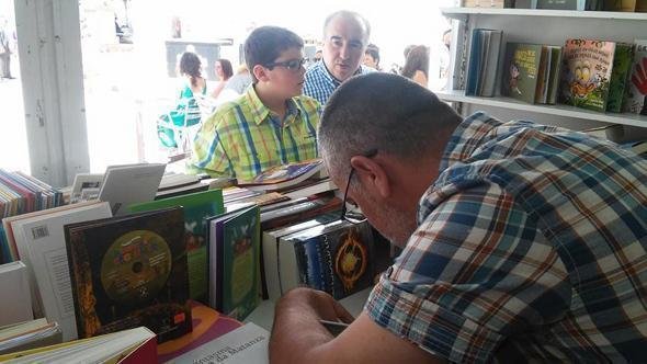 Miro Villar asinando libros nunha Feira do Libro de Cee